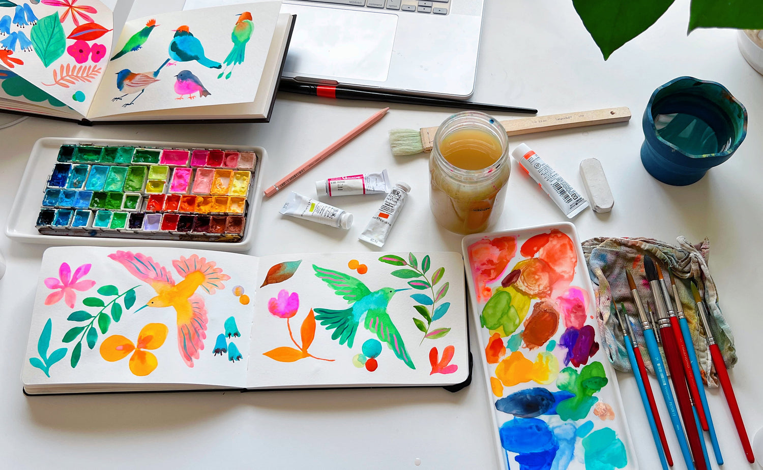 A cozy peek into Sun Lee’s art studio – a bright, creative space filled with colorful paints, brushes, and art supplies. Her desk is neatly arranged with works-in-progress, sketchbooks, and favorite tools, offering a glimpse into her artistic process and daily workspace.