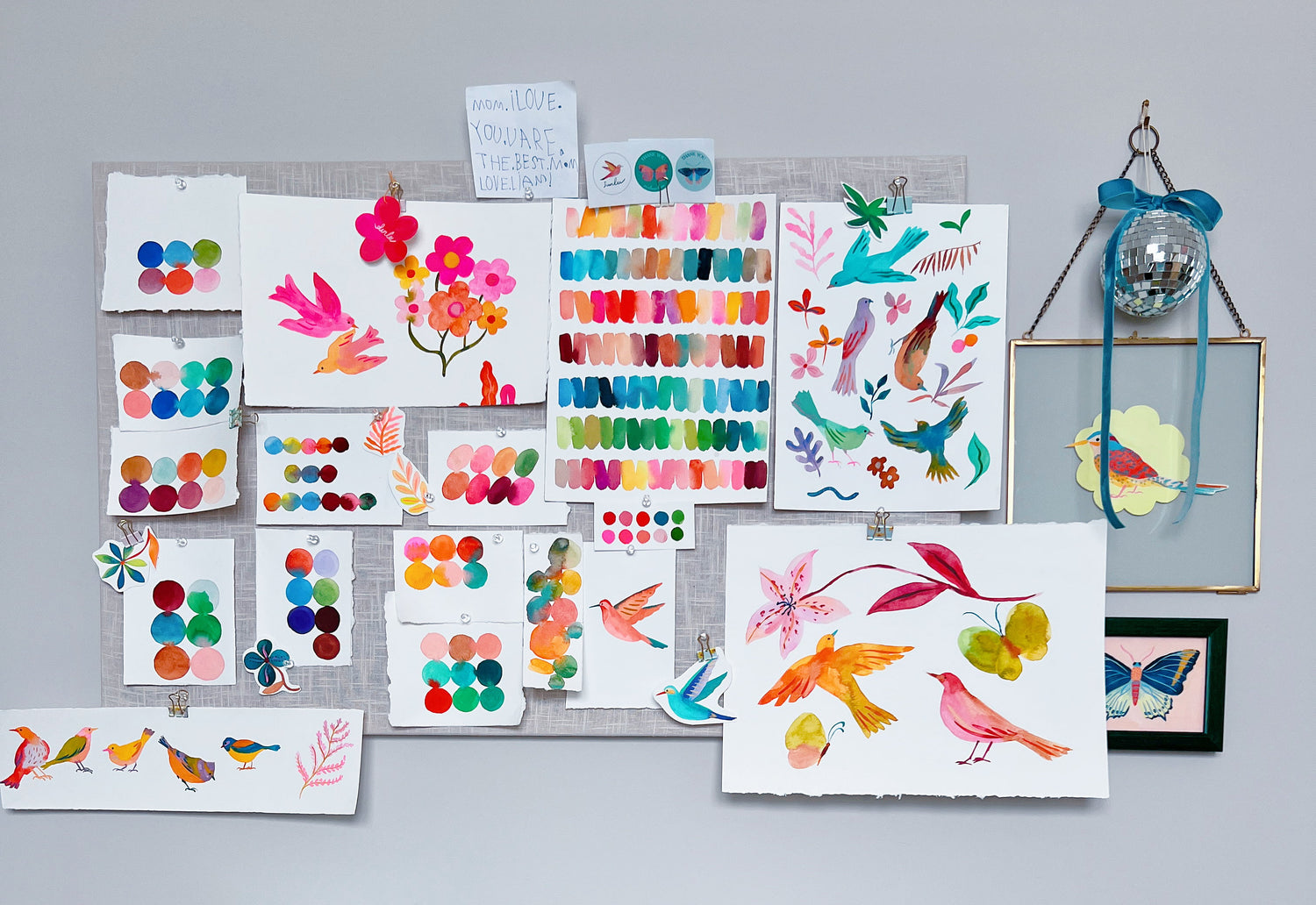 A cozy peek into Sun Lee’s art studio – a bright, creative space filled with colorful paints, brushes, and art supplies. Her desk is neatly arranged with works-in-progress, sketchbooks, and favorite tools, offering a glimpse into her artistic process and daily workspace.