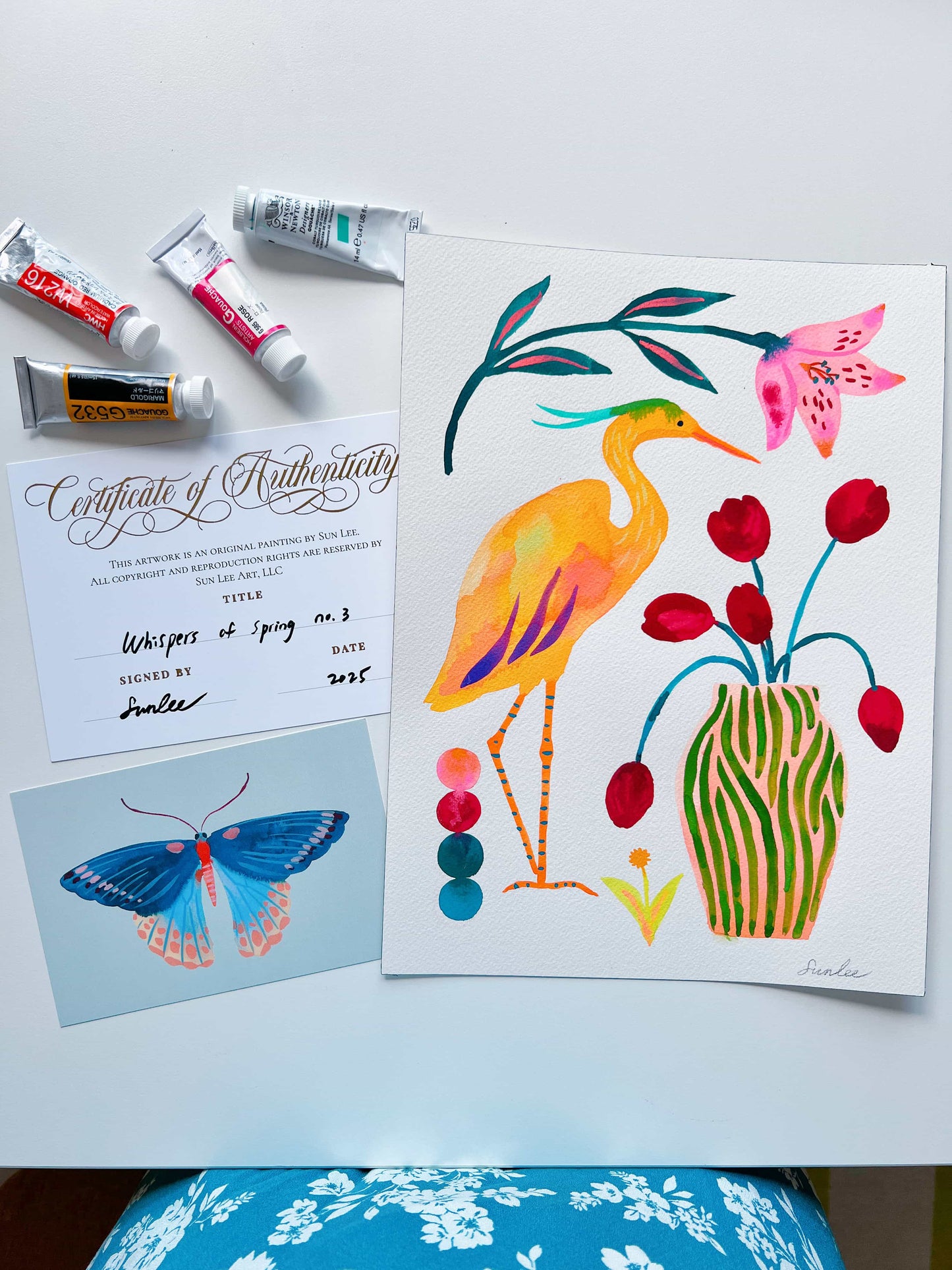 Original gouache, watercolor, and acrylic painting by Sun Lee from the 'Whispers of Spring' collection. This vibrant piece features a whimsical depiction of nature with bright flowers, butterflies, and birds, capturing the energy and beauty of spring. Perfect for nature lovers and those seeking aesthetic watercolor and gouache artwork, bringing joy and color to your space.