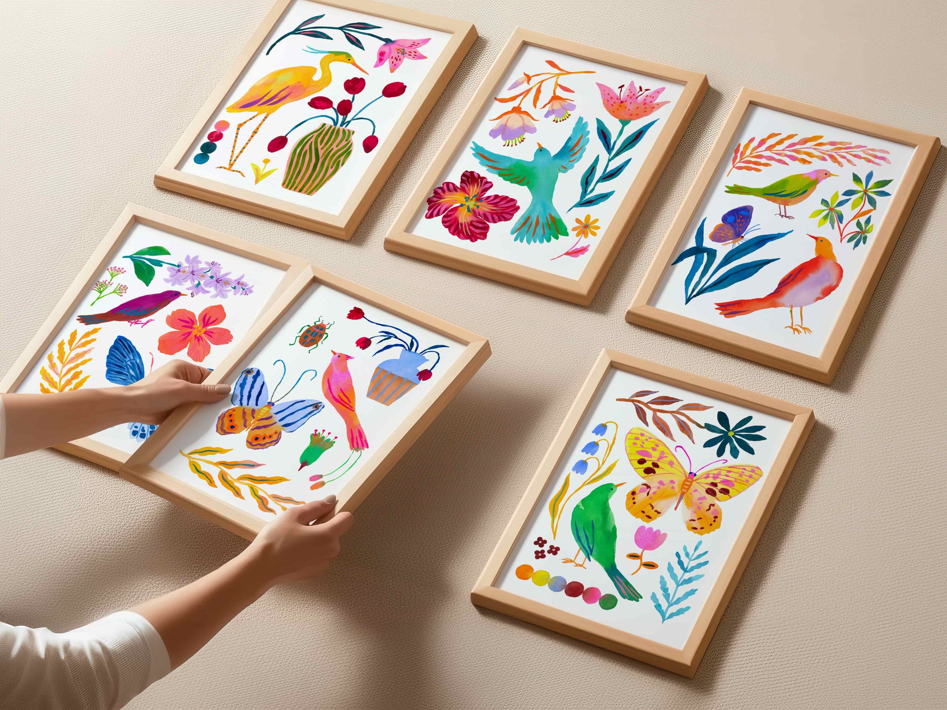 Set of six colorful framed artworks with floral and nature-themed designs on a white wall.