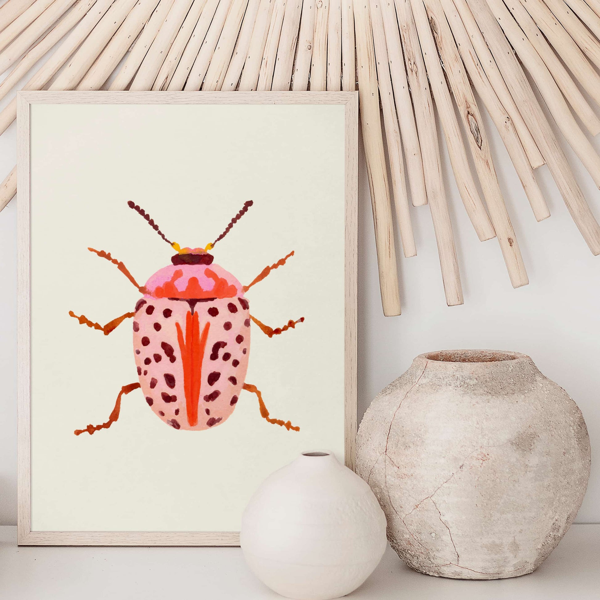 Gouache painting of a blush-colored beetle with coral and baby pink tones, accented with wine-maroon dots and curving tentacle-like antennae. A soft yet striking insect illustration.