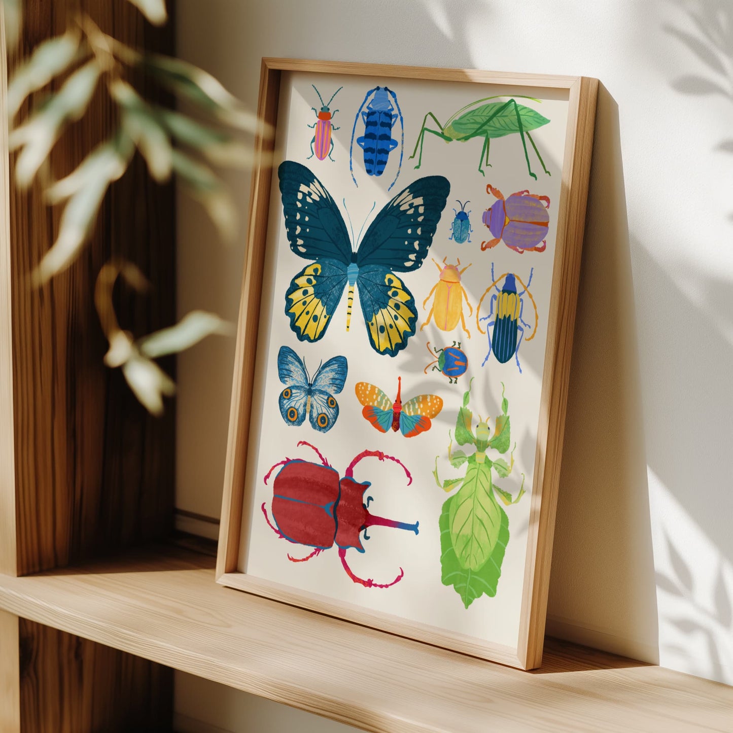 Framed artwork of colorful insects on a wooden shelf.