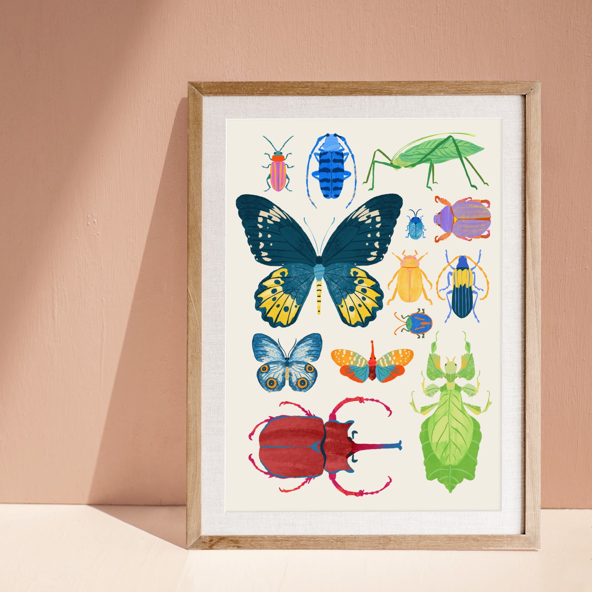 Framed artwork of colorful insects on a beige wall