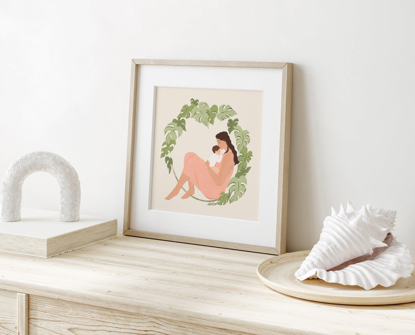 Tender art print of a mother and baby surrounded by lush monstera foliage – serene illustration with soft textures celebrating nurturing and natural beauty
