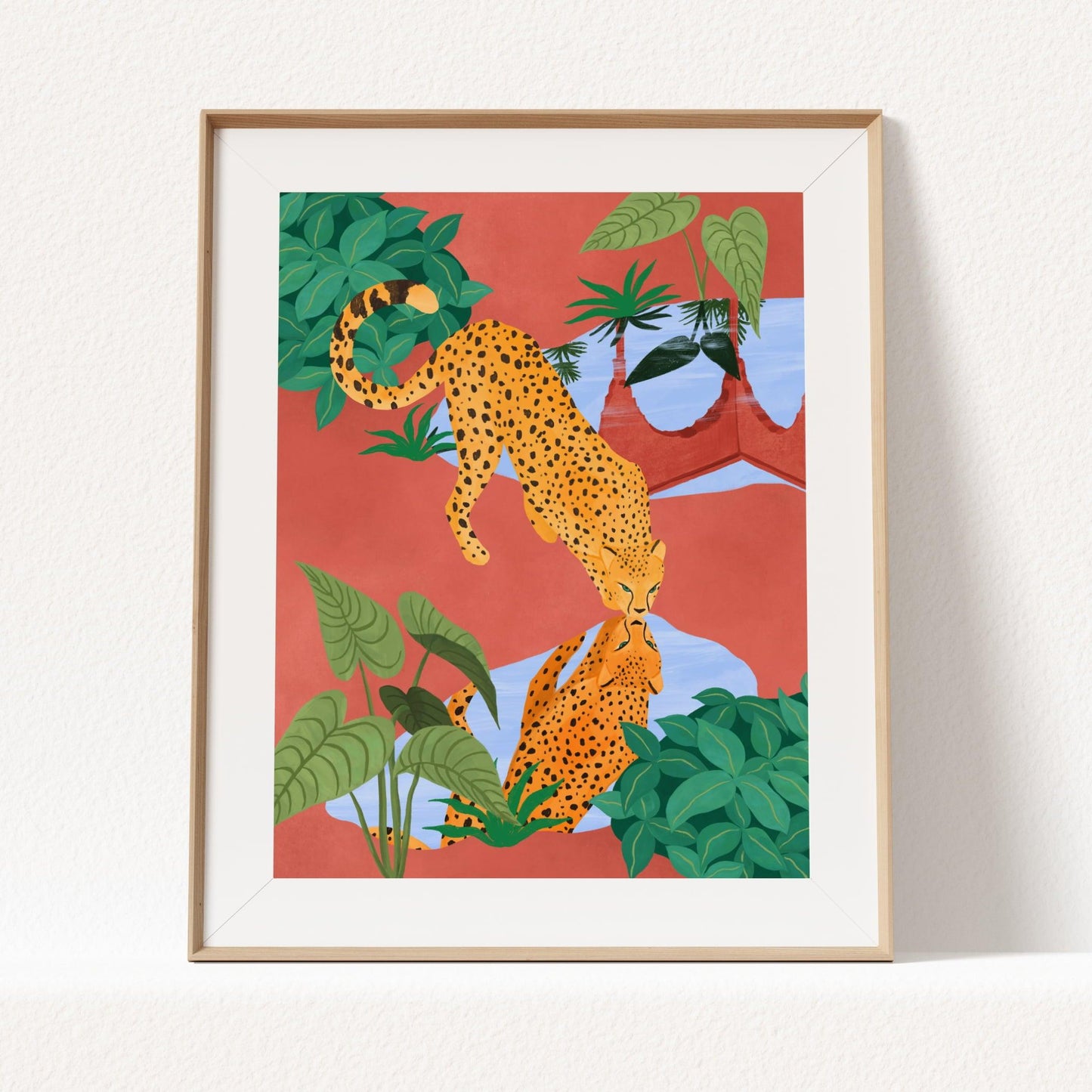 Giclee art print of a cheetah drinking water from a serene pond, with a beautiful reflection – earthy mud tones and vibrant greens in tranquil nature art print for modern home decor