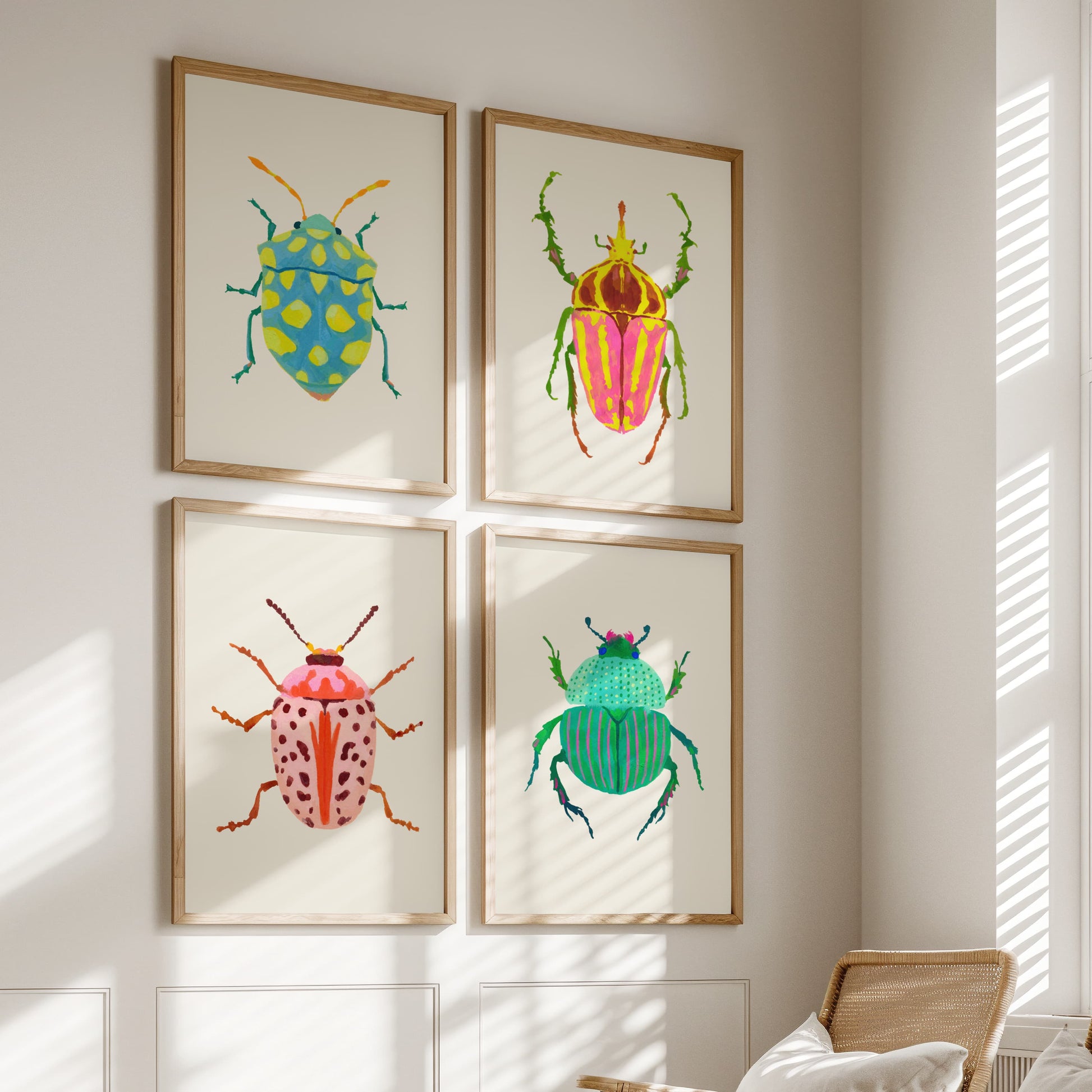 Four framed illustrations of colorful beetles on a wall.
