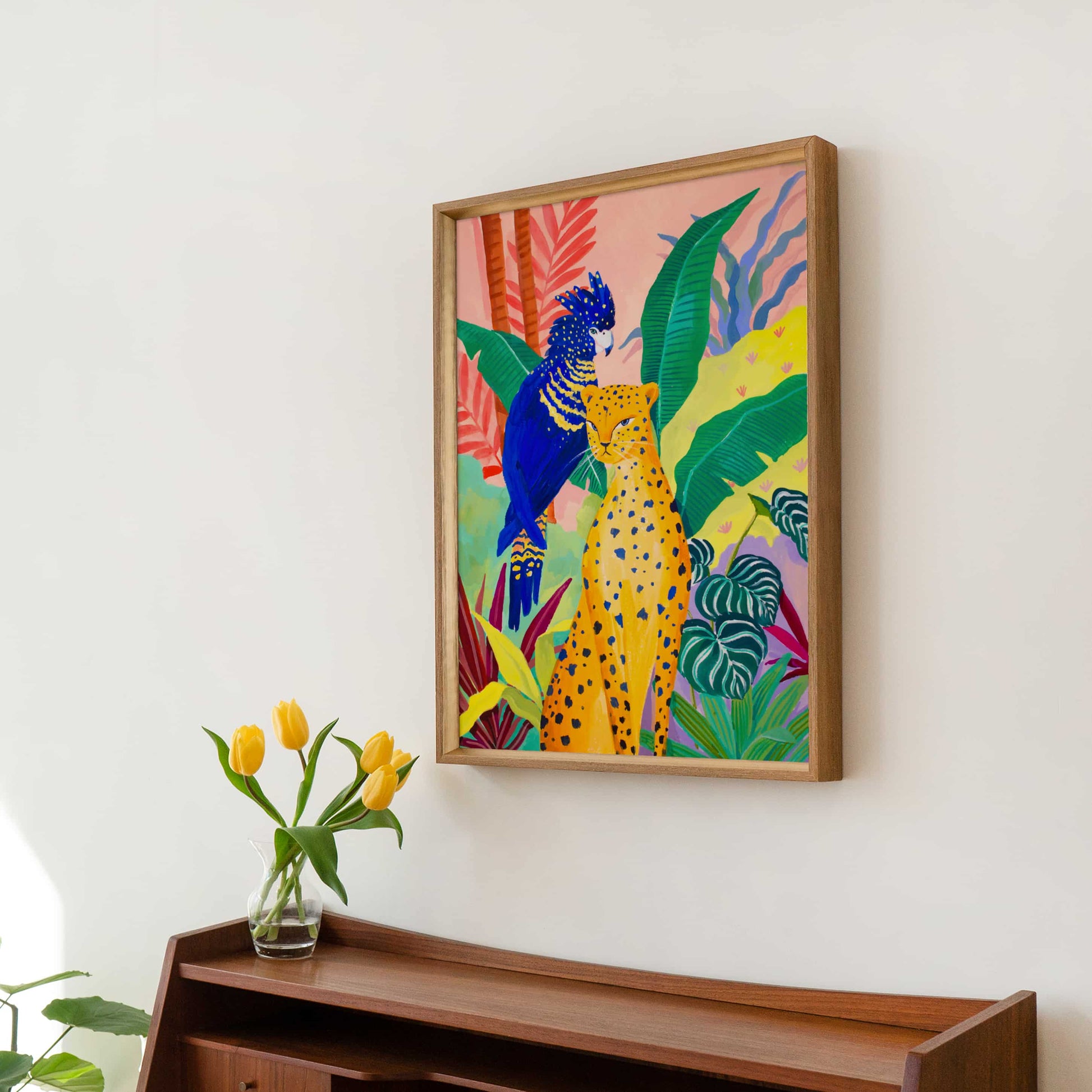 Watercolor and gouache jungle illustration featuring a cheetah, tropical foliage, and a bright blue cockatoo.