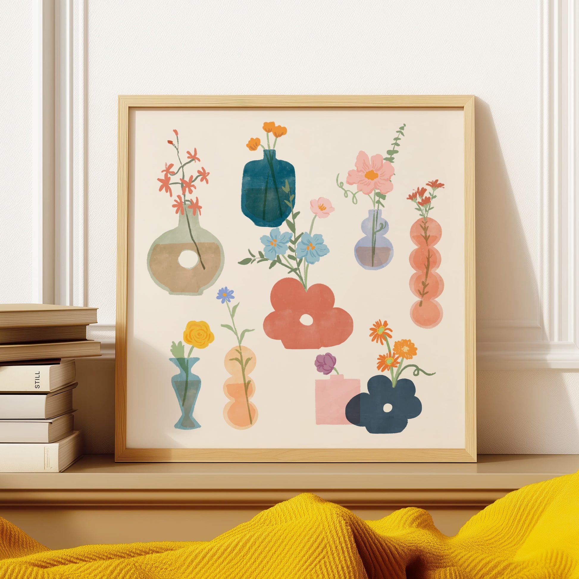 Framed artwork with colorful floral and vase designs on a shelf.