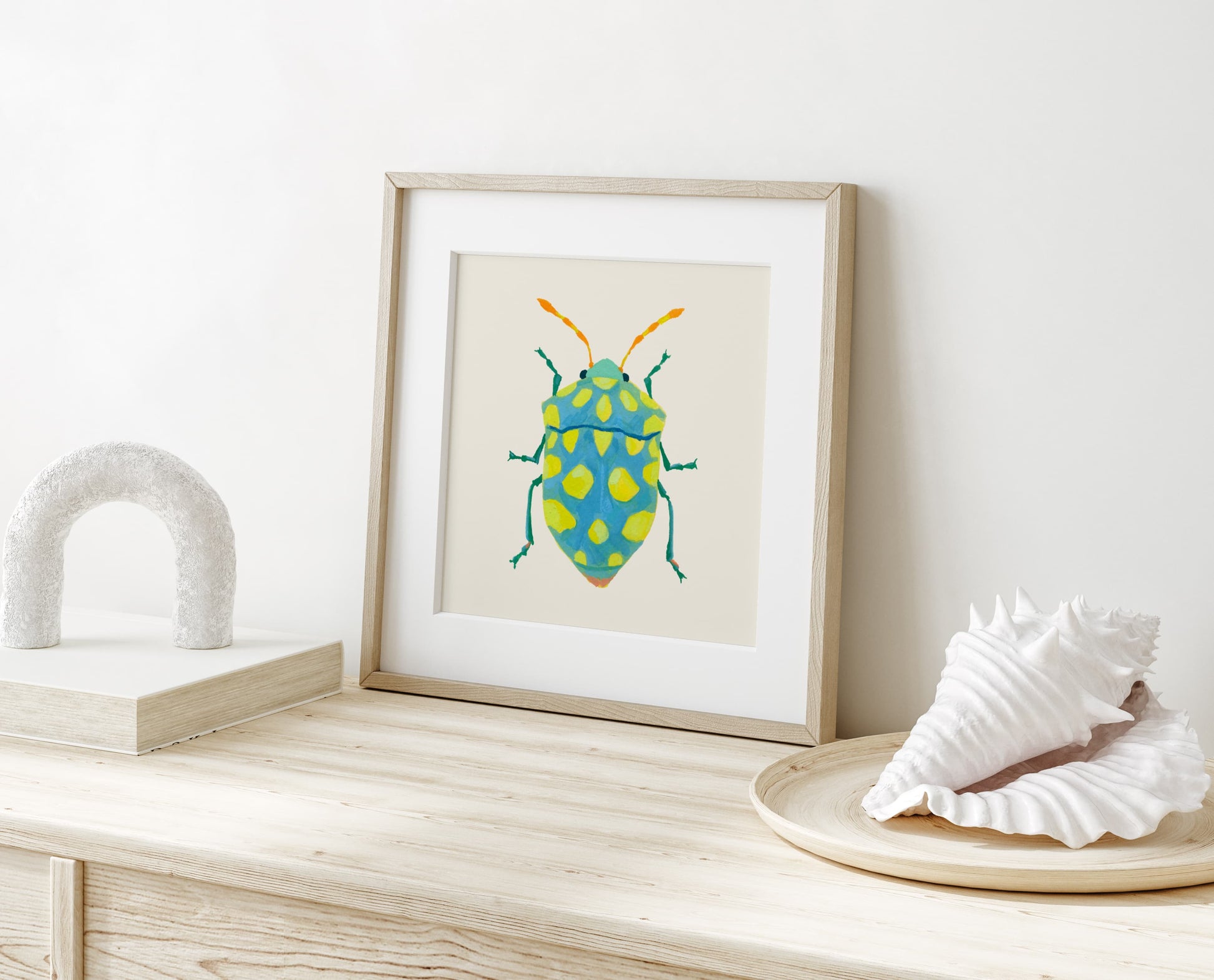 Whimsical insect illustration of a sky blue beetle featuring lime spots and striking yellow-orange antennae, hand-painted with gouache.