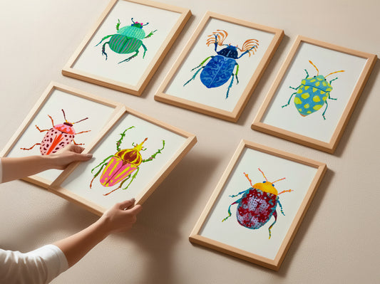 Framed illustrations of colorful beetles on a beige surface