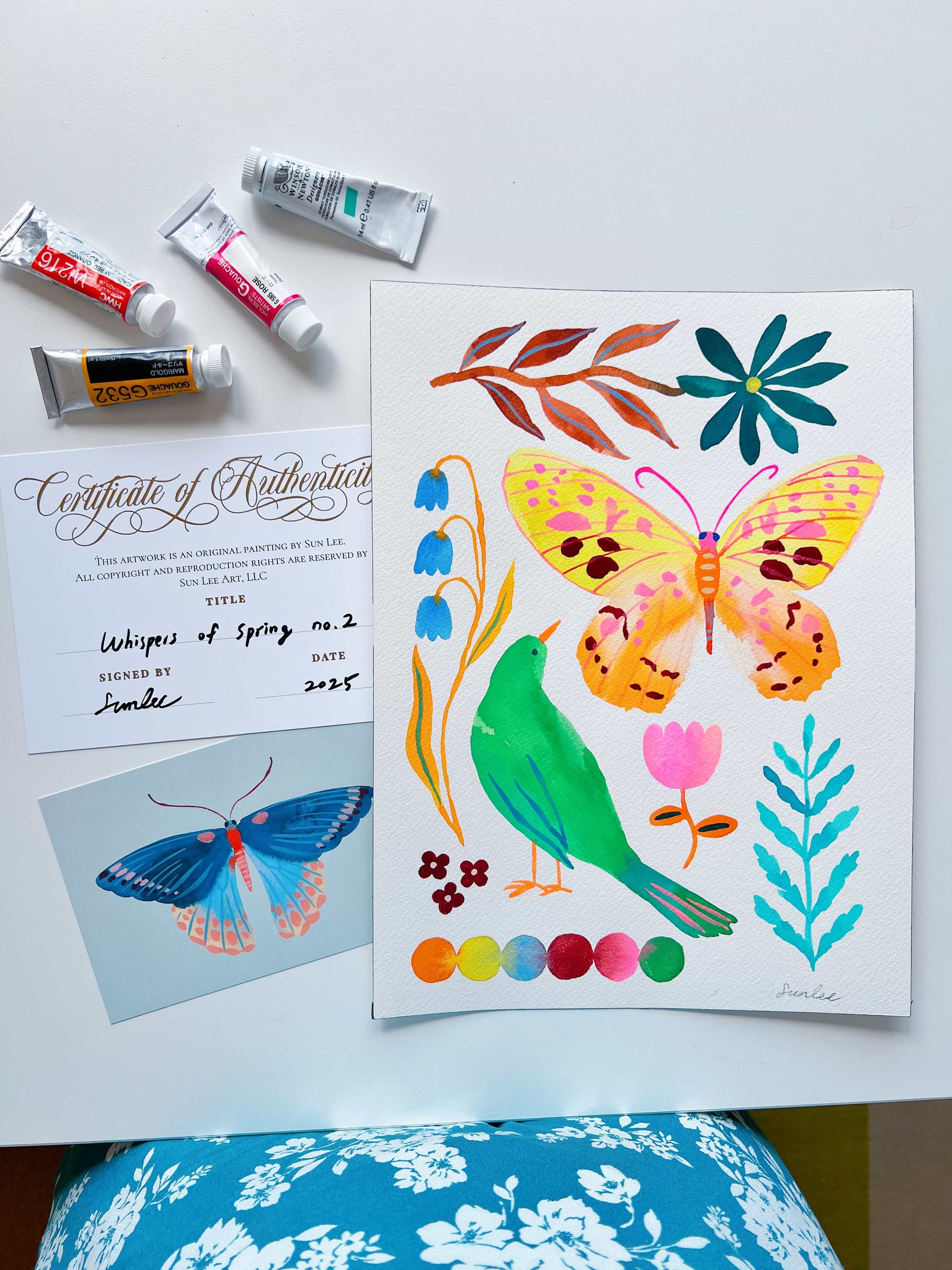Original gouache, watercolor, and acrylic painting by Sun Lee from the 'Whispers of Spring' collection. This vibrant piece features a whimsical depiction of nature with bright flowers, butterflies, and birds, capturing the energy and beauty of spring. Perfect for nature lovers and those seeking aesthetic watercolor and gouache artwork, bringing joy and color to your space.